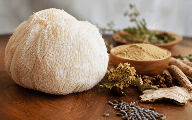 Hongo melena de león blanco sobre madera natural junto a ingredientes funcionales